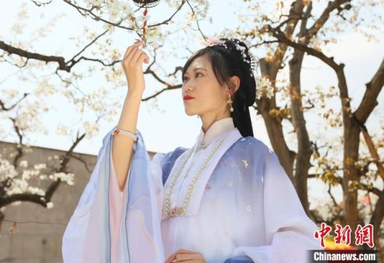 圖為蘭州青年身穿漢服在百年梨園賞景?！「哒?攝