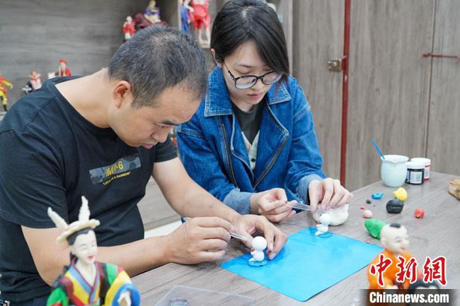 <a target='_blank'  data-cke-saved- >中新社</a>記者(右)現(xiàn)場體驗(yàn)面塑制作過程?！￡悹帍?qiáng) 攝