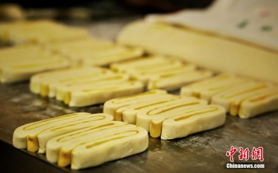 圖為面劑被涂上胡麻油，切成條狀用作月餅的花型制作。張文 攝