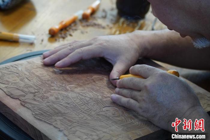 圖為徐晉林湊近木板，近距離制作雕版畫?！【琶赖┰?　攝