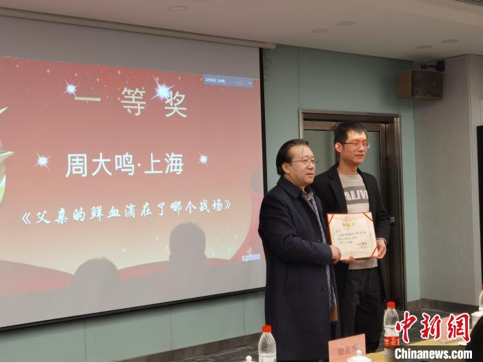 圖為作家、西北師范大學(xué)新聞與傳媒學(xué)院院長徐兆壽頒發(fā)一等獎證書，代領(lǐng)獎?wù)呱吓_領(lǐng)獎?！钅?攝