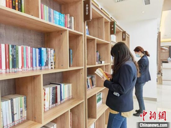 圖為在甘肅公航旅建設(shè)集團(tuán)有限公司的職工書屋，職工挑選書籍?！⌒煅?攝
