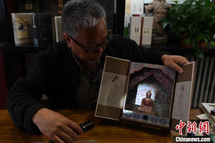 圖為讀者出版集團(tuán)讀者晉林工作室獨(dú)立出品人徐晉林，展示互動(dòng)性強(qiáng)的敦煌題材手工書(shū)。(資料圖) 楊艷敏 攝
