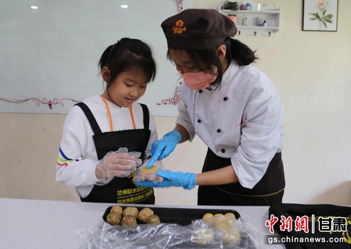 圖為在甘臺(tái)胞小朋友在工作人員指導(dǎo)下制作月餅。九美旦增 攝