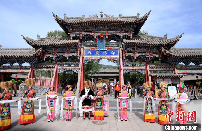 圖為身穿土族服飾的工作人員迎接訪客?！⊙Φ?攝