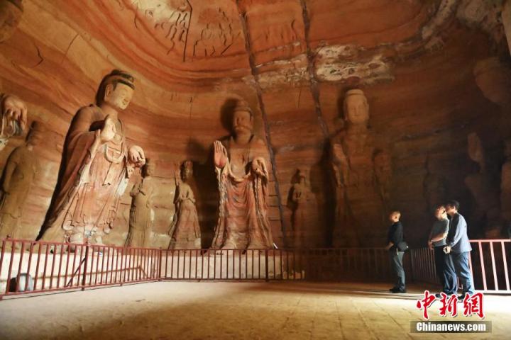 7月15日，游人參觀甘肅省平?jīng)鍪袥艽h百里石窟長廊中的南石窟寺1號窟。百里石窟長廊位于涇川縣境內(nèi)，由512個石窟、5眼窟中石井組成，現(xiàn)存王母宮石窟、鳳凰山石窟、南石窟寺、丈八寺石窟、羅漢洞石窟、太山寺石窟等規(guī)模較大的石窟群，還有數(shù)量眾多的小石窟群。南石窟寺開鑿于北魏永平三年，其中1號窟屬于大型七佛窟，七佛高達6米。中新社記者 李亞龍 攝